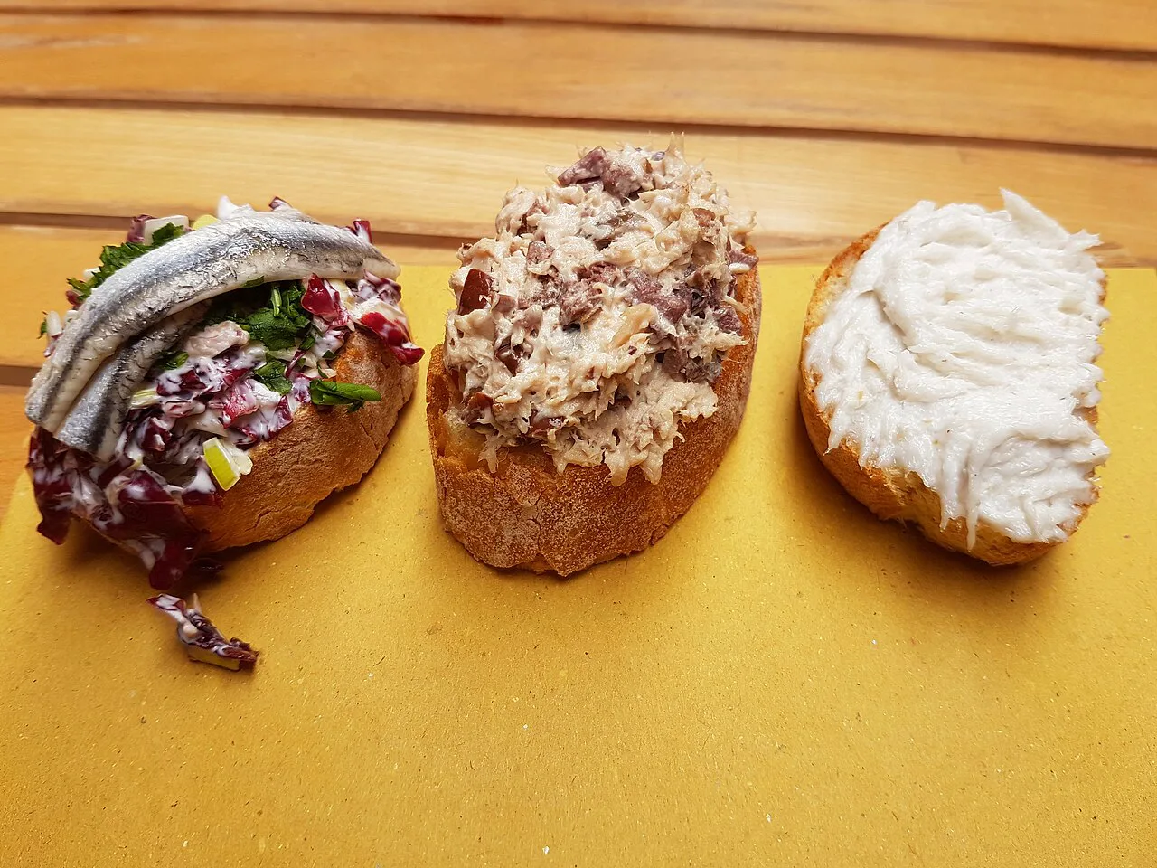 Crostini topped with sardines and creamed salt cod.