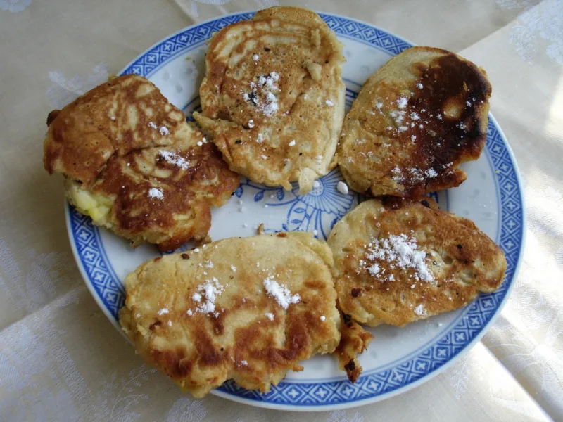 Apple pastries dusted with sugar on a plate.