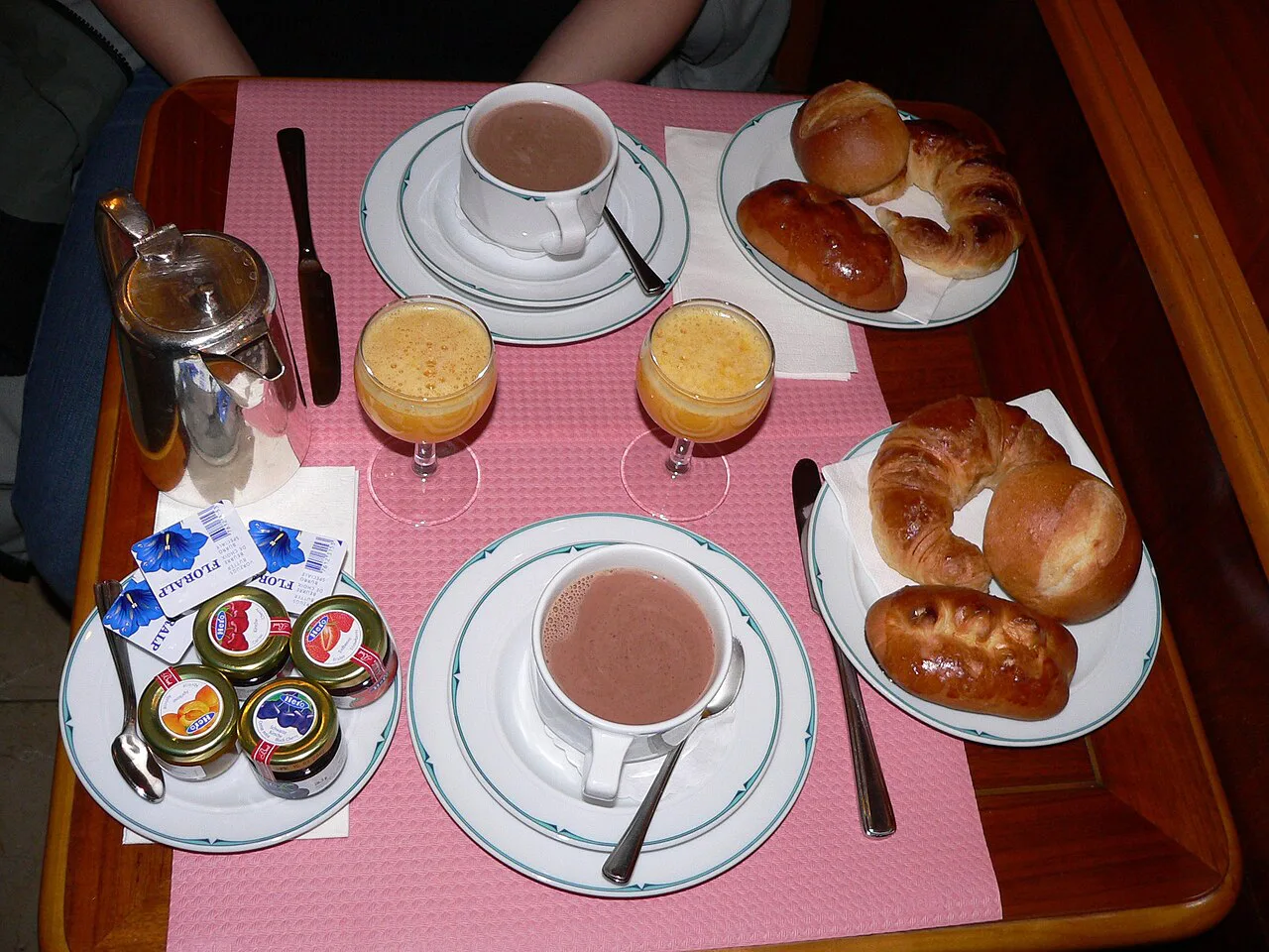 A continental breakfast with croissants, juice and hot drinks.