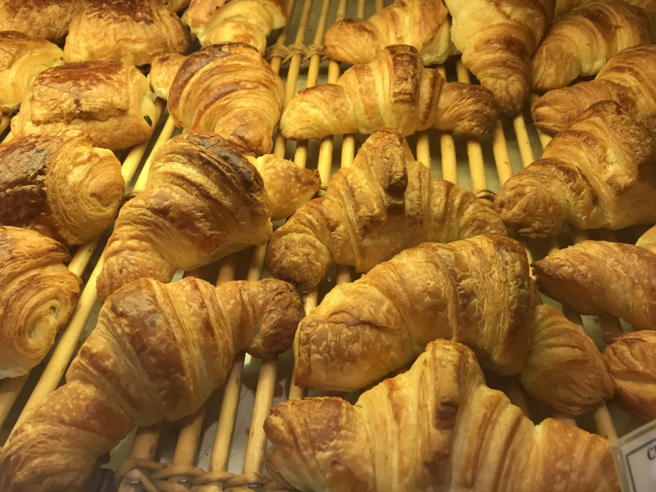 Trays of croissants in a bakery.