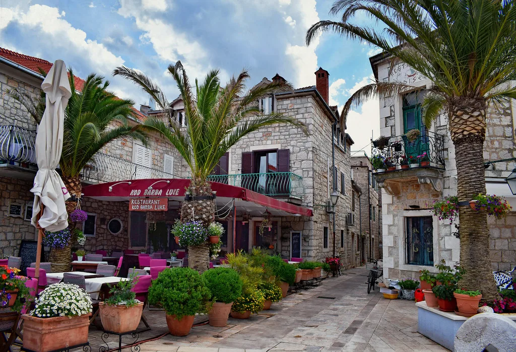 Café tables among flowers in the old town of Stari Grad, Hvar island.