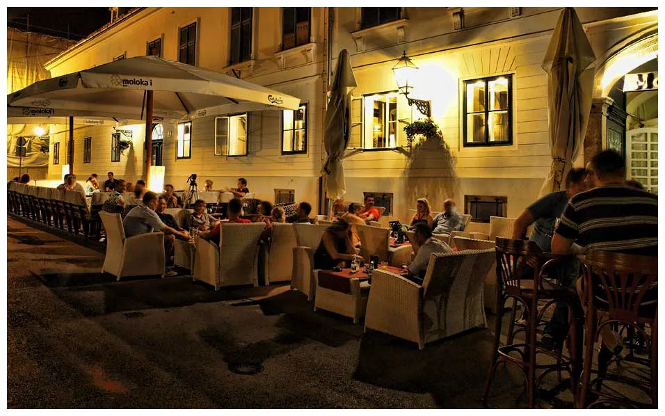 Café terraces on a Zagreb street at night.