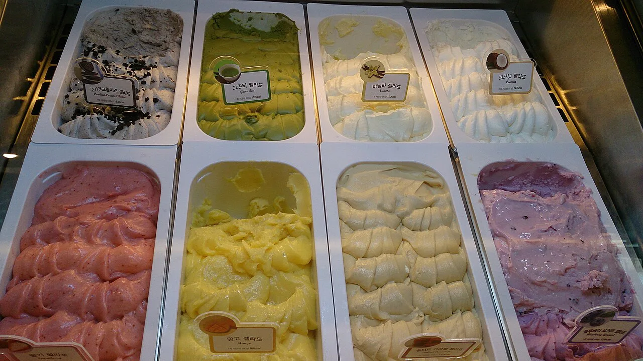 Trays of gelato in a shop counter.