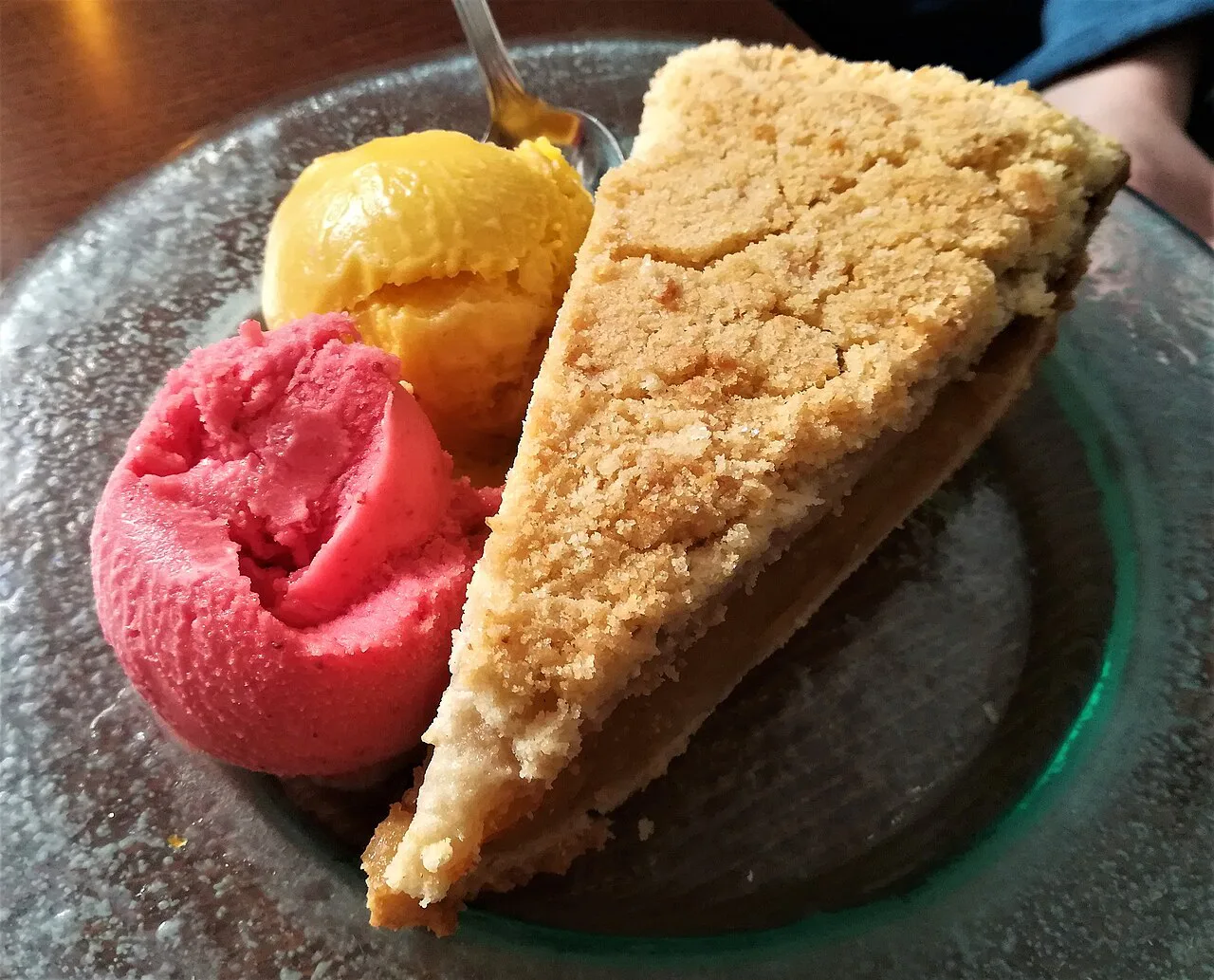 Scoops of ice cream served with a slice of apple cake.