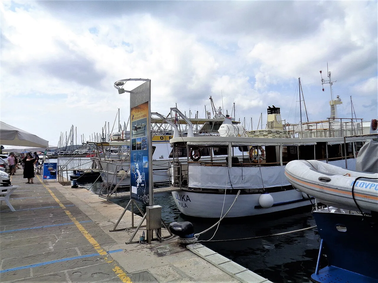 Boats moored along the harbour quay, Pula.