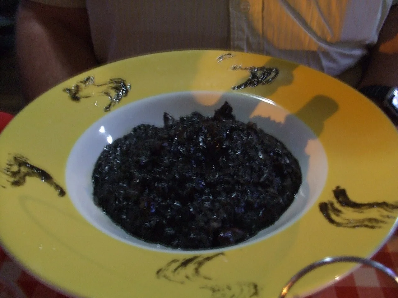 Crni rižoto, black risotto, in a bowl.