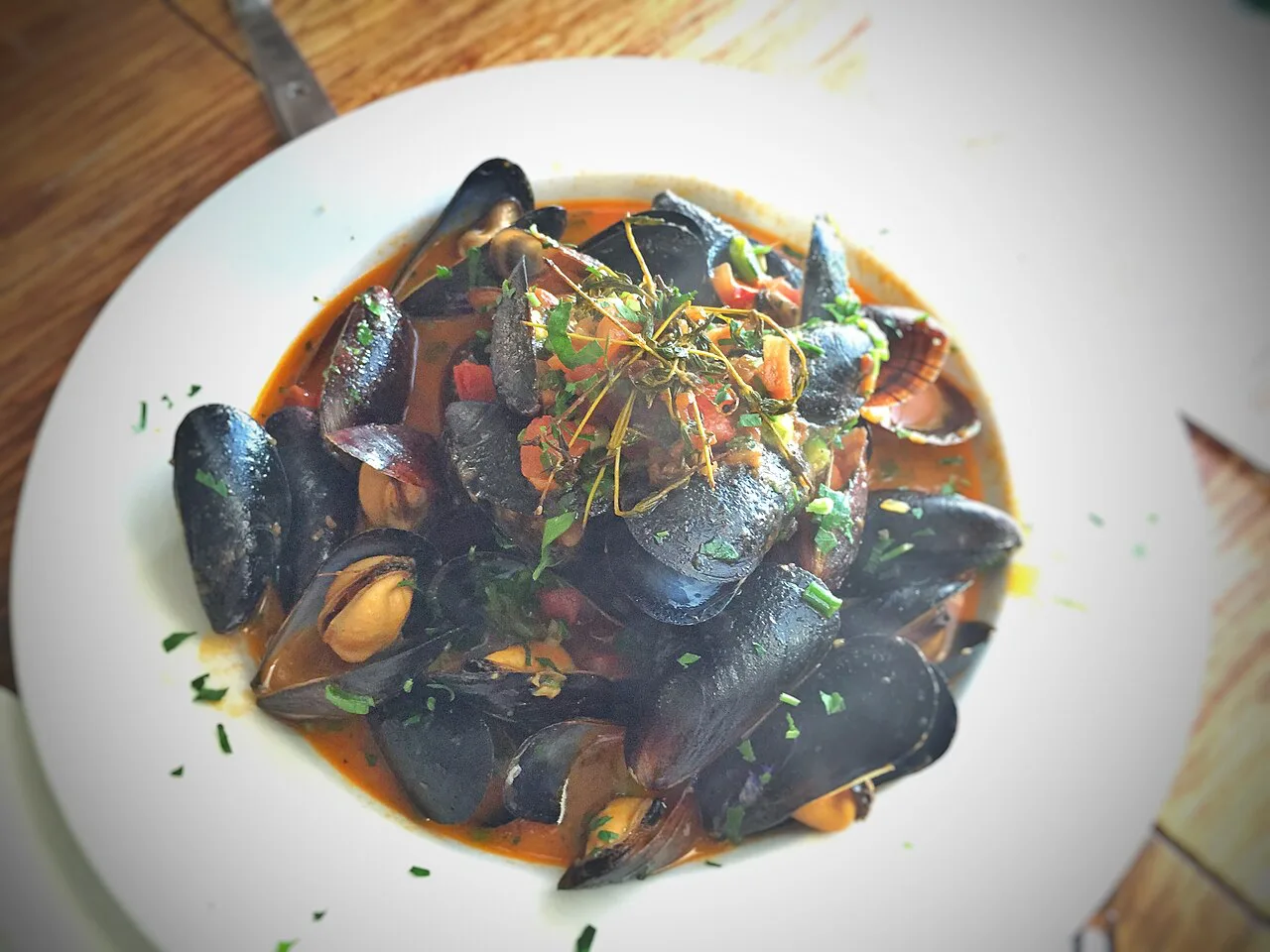 A bowl of mussels in a tomato broth.