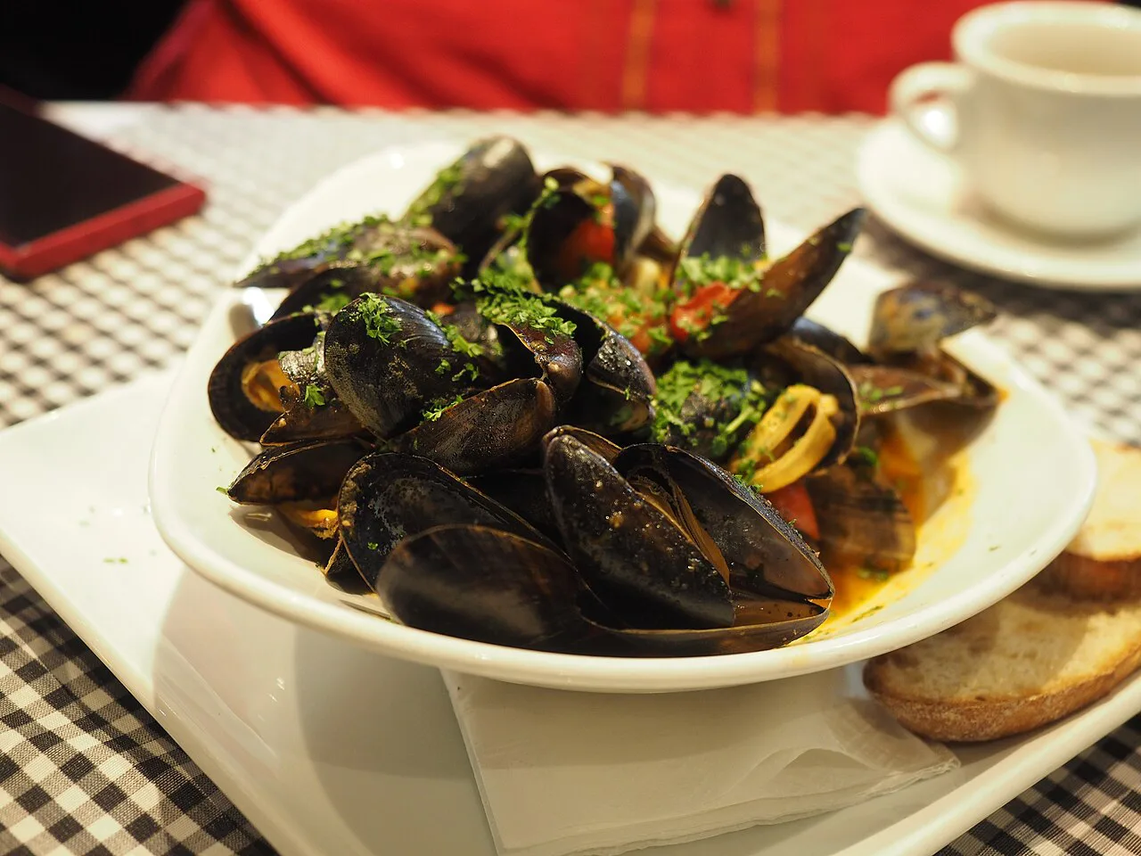A plate of mussels in sauce.