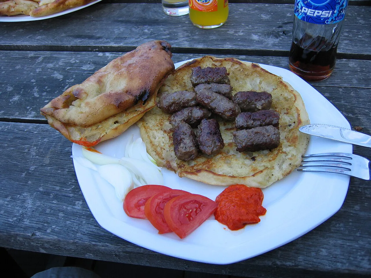 Ćevapčići with ajvar and lepinja bread.