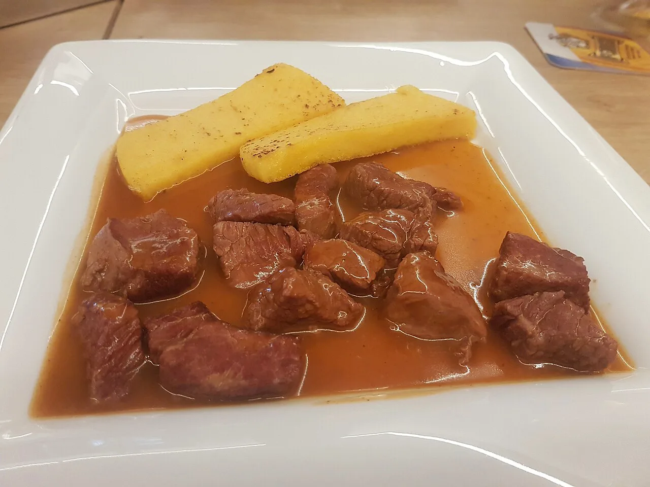 Beef goulash served with slices of polenta.