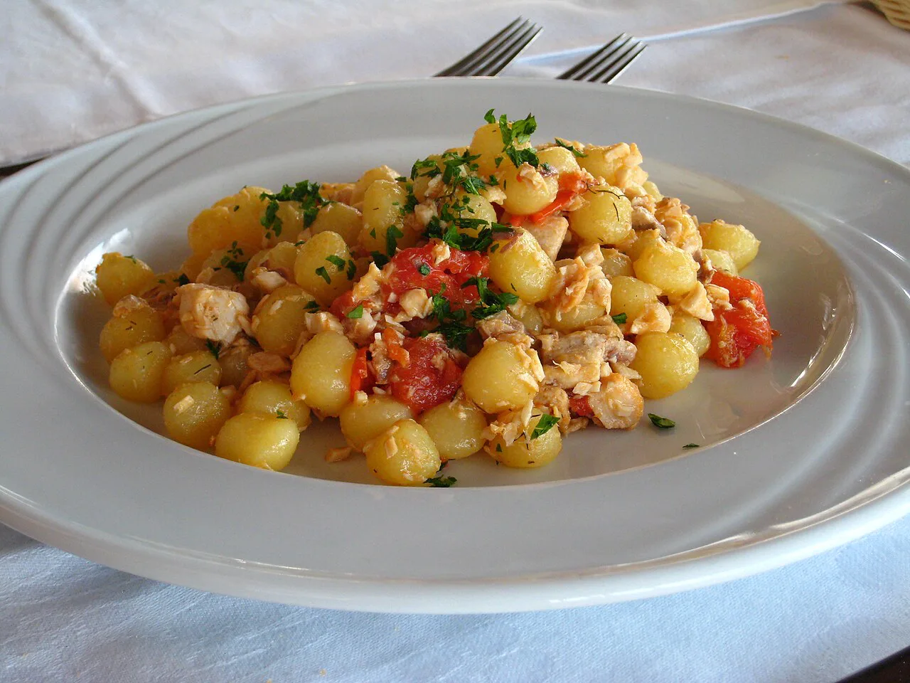 A plate of gnocchi with tomato.