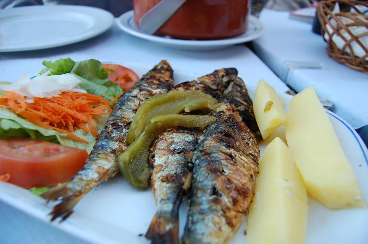 Charcoal-grilled sardines with salad and potatoes.