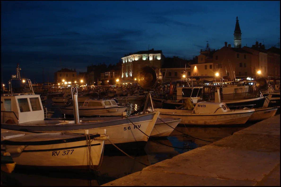 Fishing boats in Rovinj harbour at night.