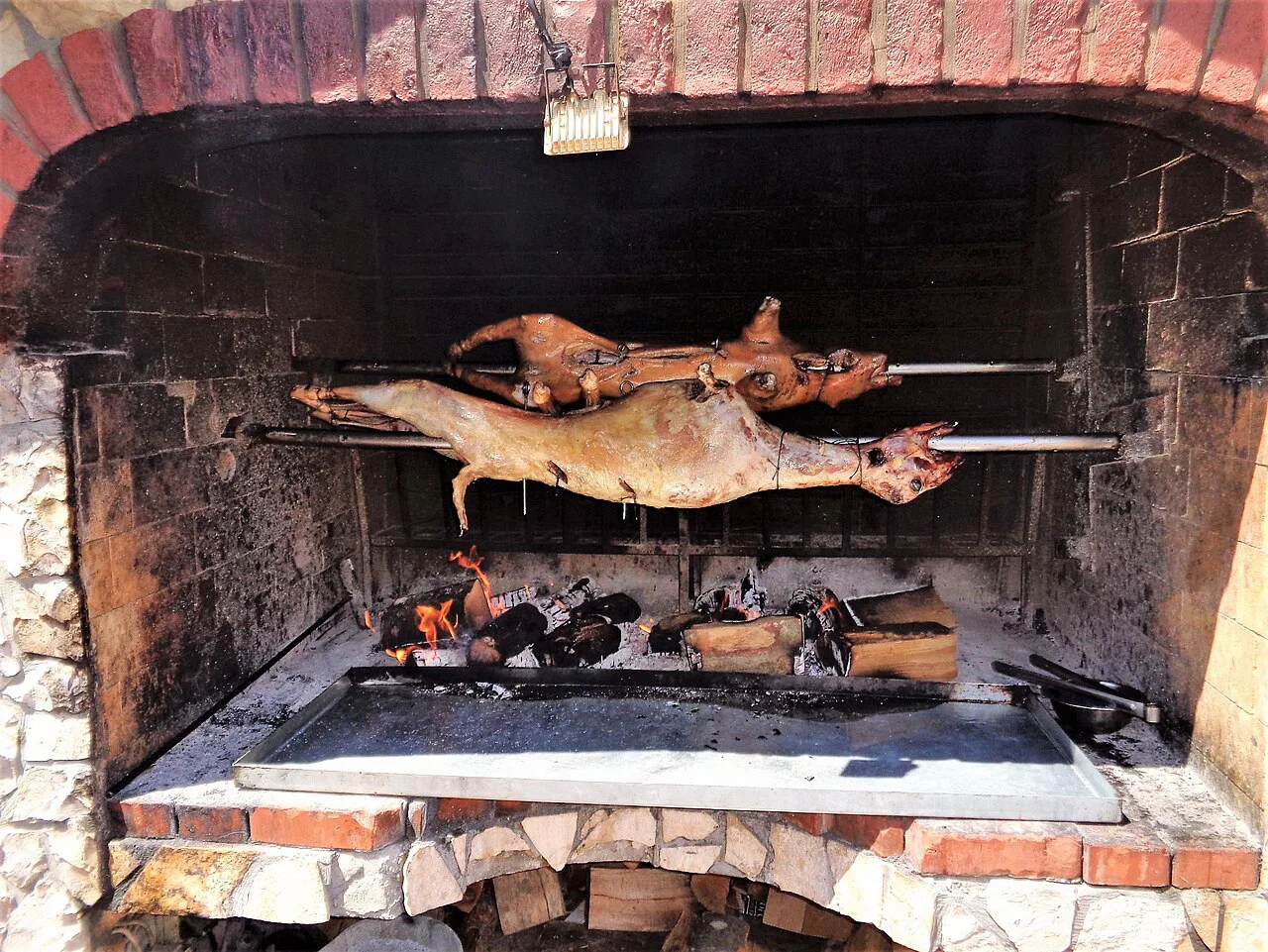 Lamb and suckling pig turning over the coals, Novalja, Pag.