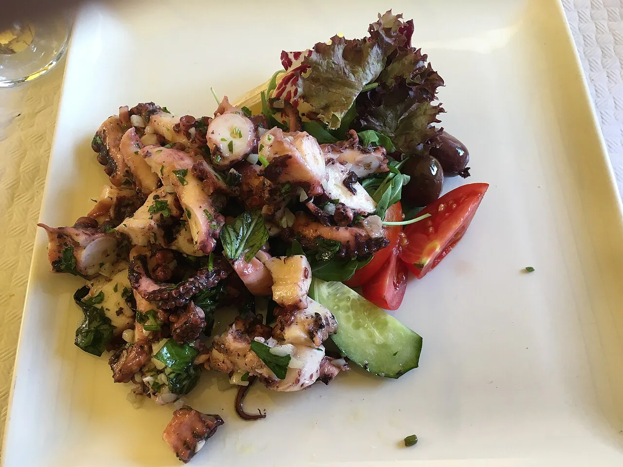 Octopus salad with tomato and cucumber.