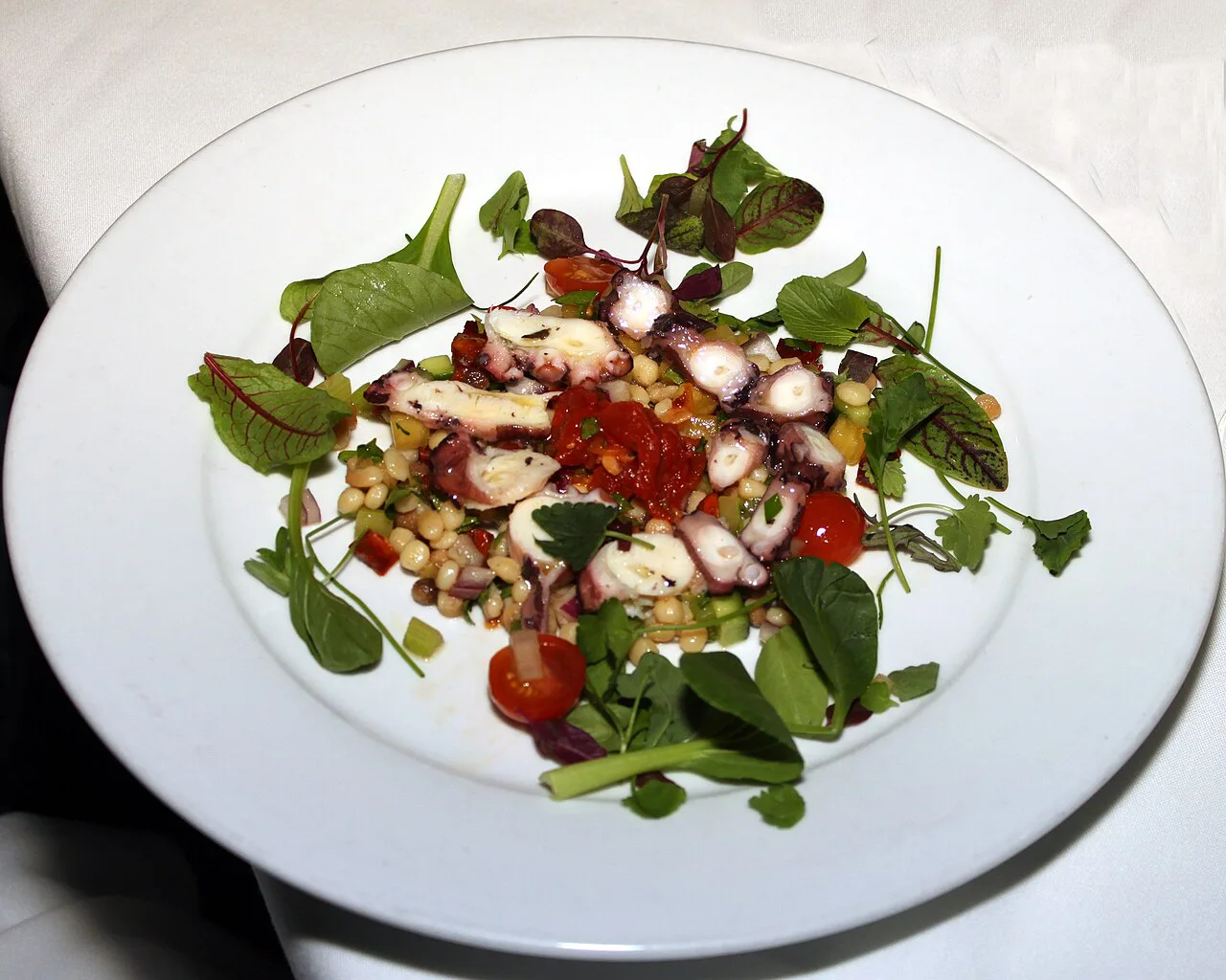 Octopus salad with chickpeas, tomatoes and greens.