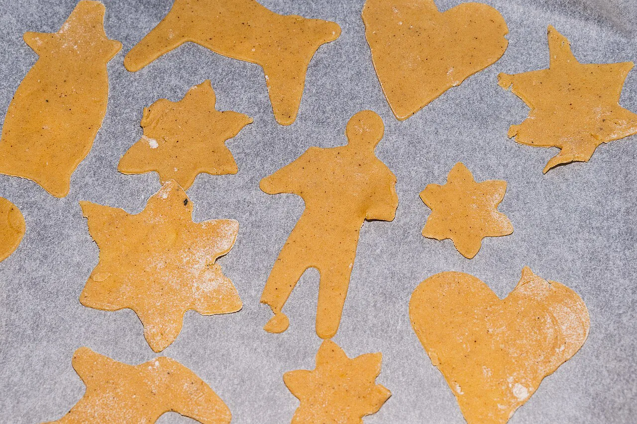 Spiced gingerbread dough cut into biscuit shapes.