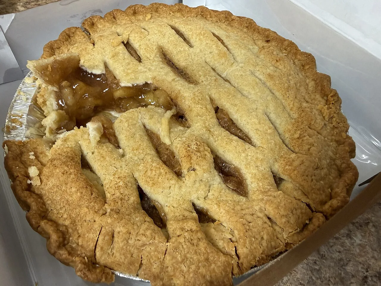 An apple pie with a slice removed.