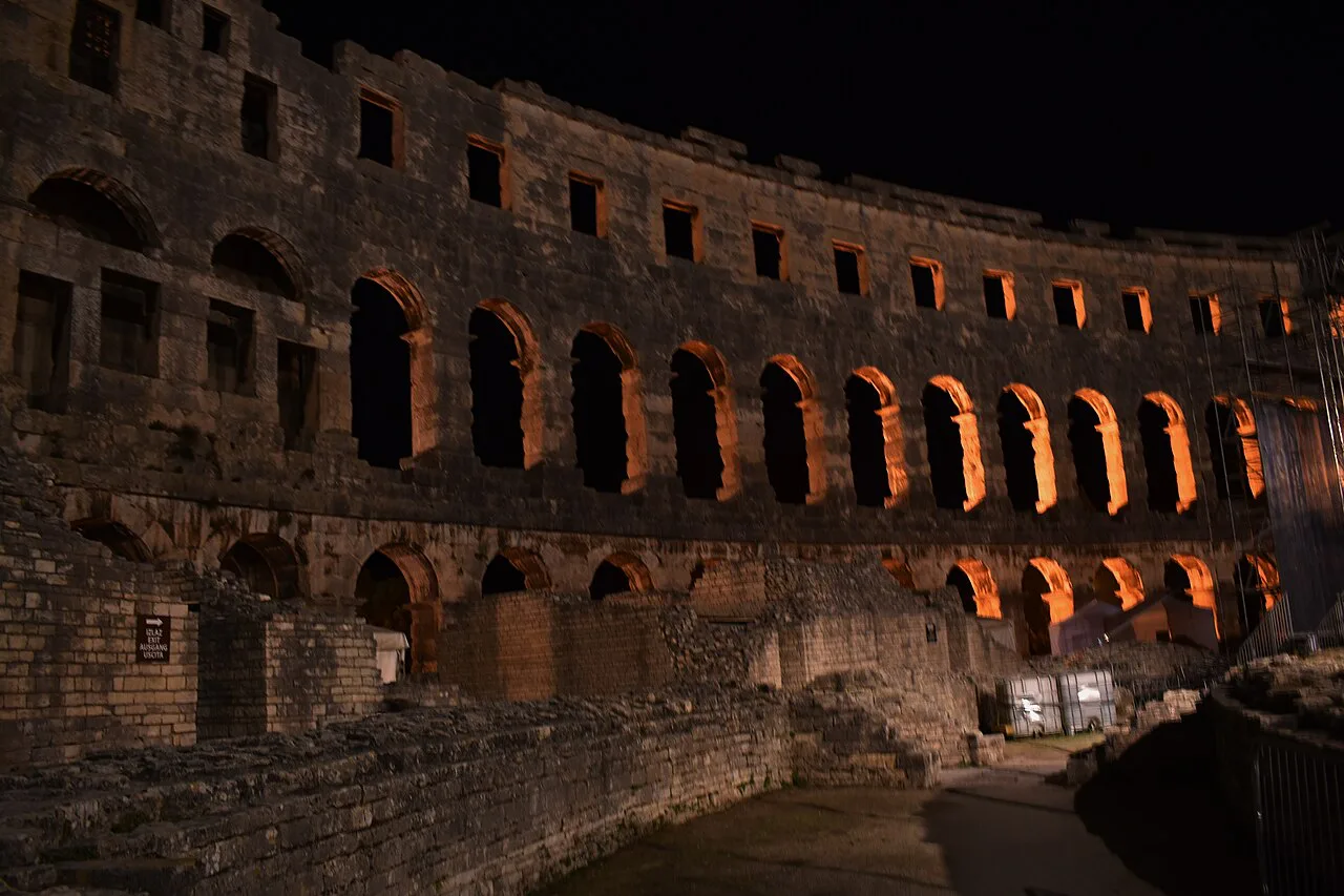 The Pula Arena lit at night.
