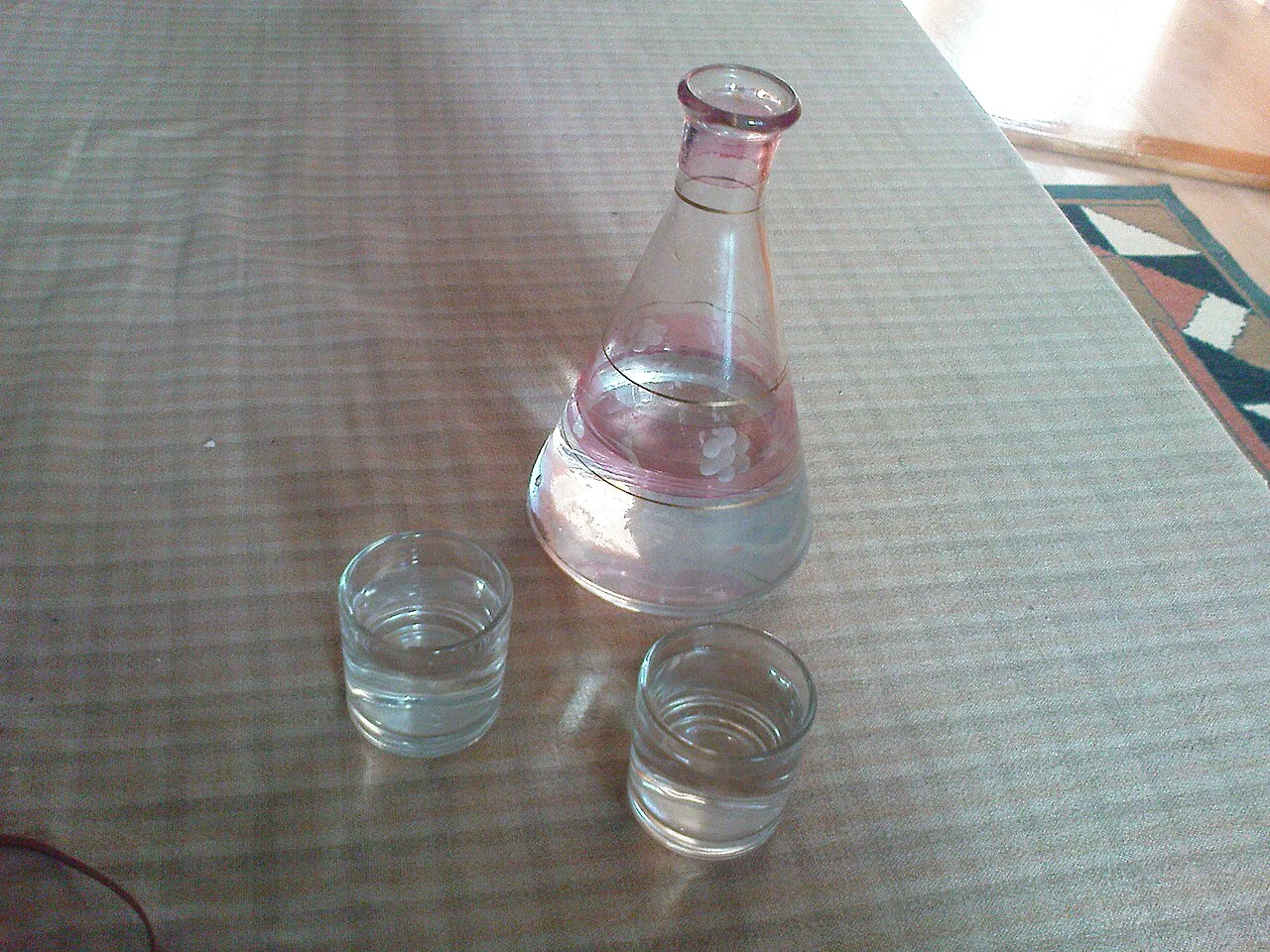 Rakija in a carafe with small glasses.
