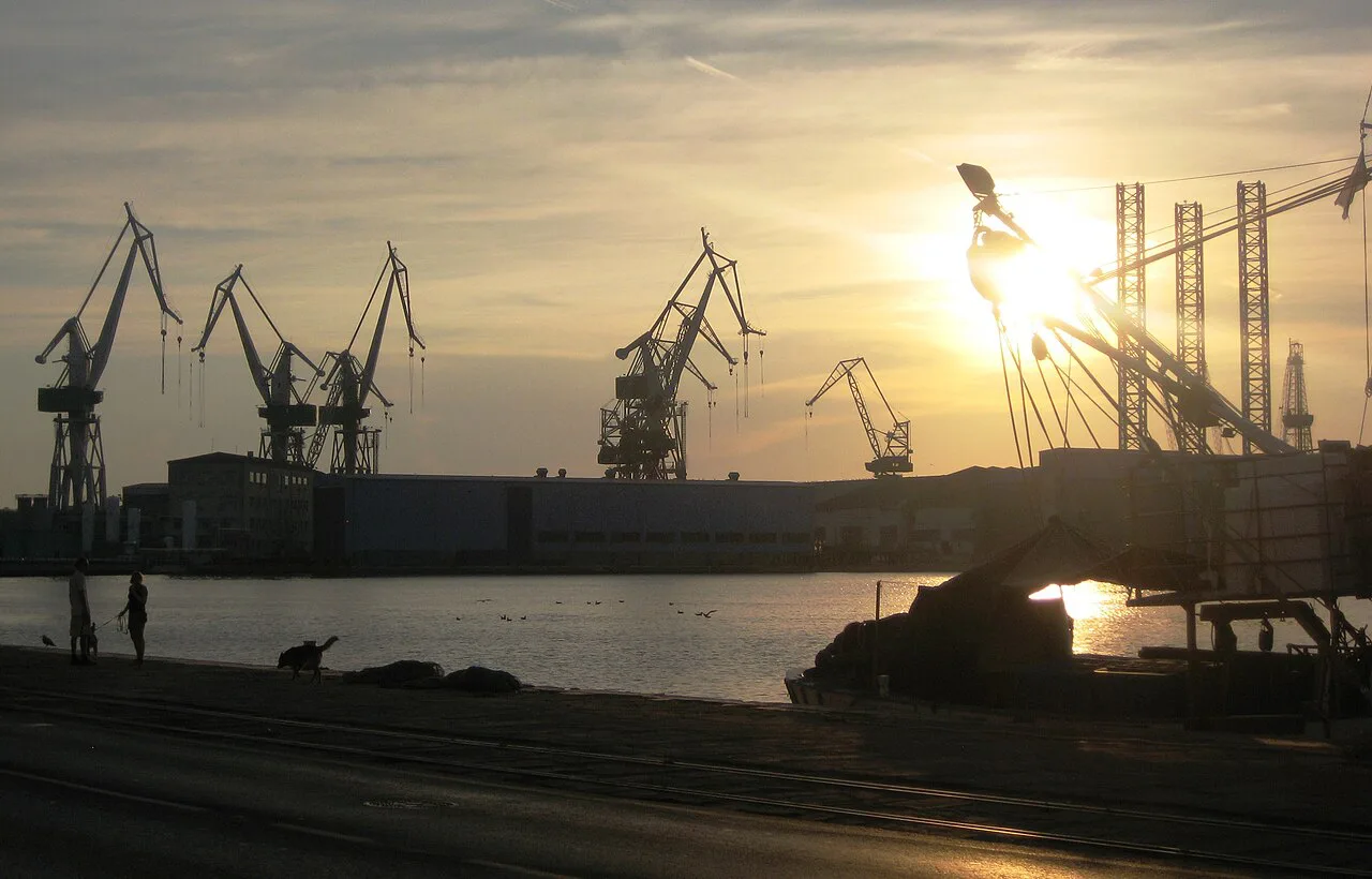 Shipyard cranes over Pula harbour at sunset.