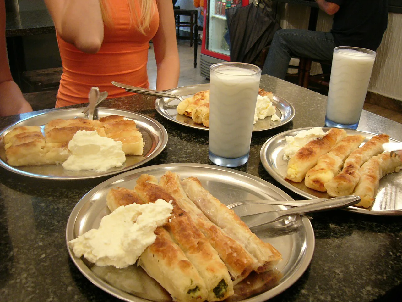 Plates of sirnica served with yoghurt.