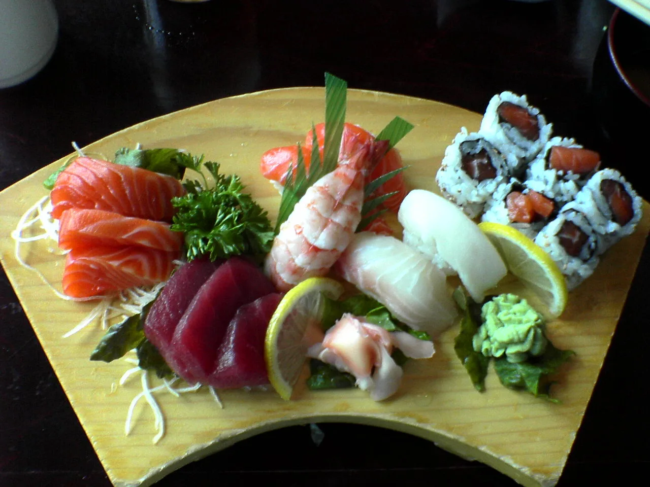 A plate of sashimi and sushi rolls.