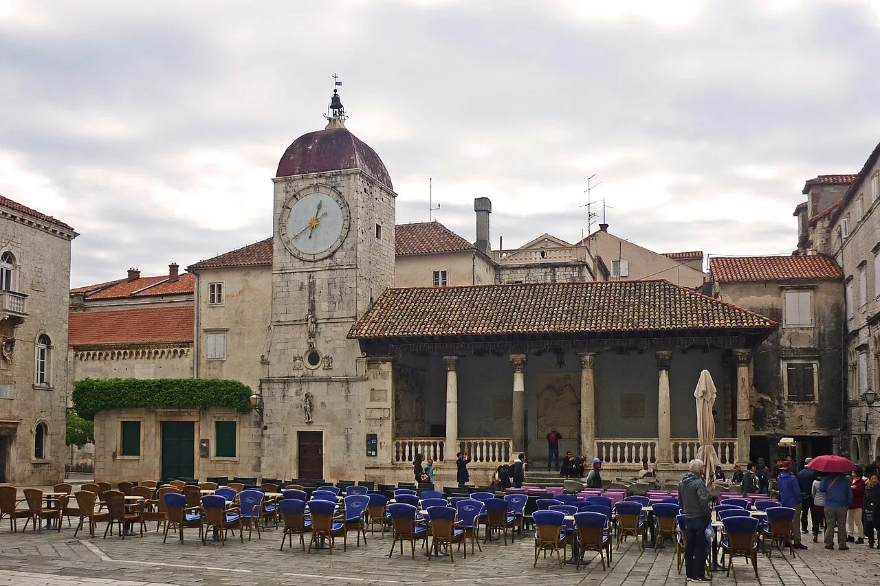Café terraces by the loggia in Trogir's main square.