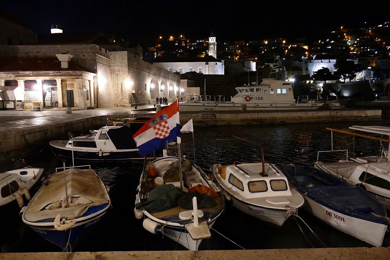 Boats in Dubrovnik's old harbour at night.