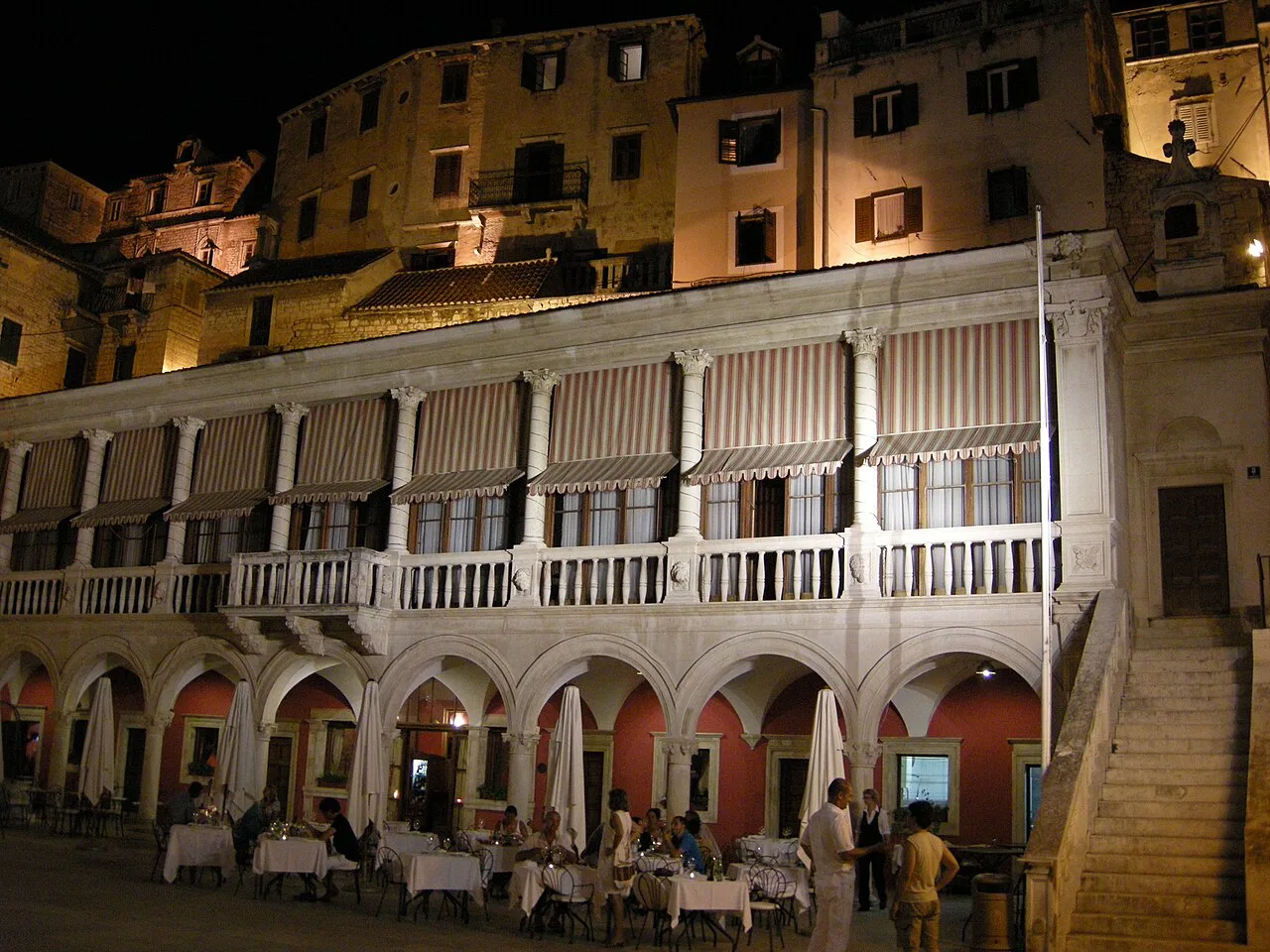 Restaurant tables on the square by the Cathedral of St James at night, Šibenik.