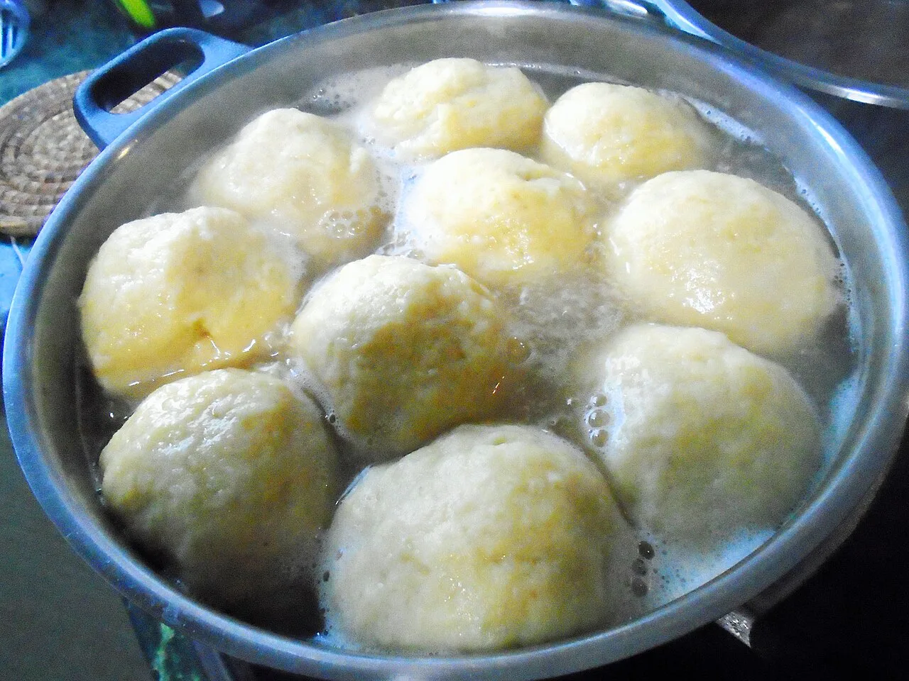 Apricot-filled dumplings cooking in a pot, a Međimurje recipe.
